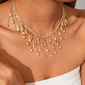 Gros plan du collier ras de cou doré à franges avec cristaux champagne scintillants