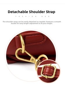 Detail view of the adjustable red leather shoulder strap with golden metal clasp hardware