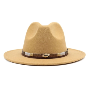 Macro detail of camel wool felt fedora with braided band and golden shell ornament
