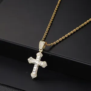 Detail of hip hop cross pendant with paved zircons and golden rope chain on black stand