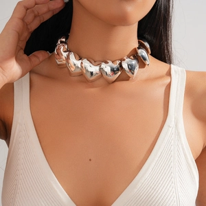 Close-up of chunky silver heart choker necklace with polished metallic mirror finish