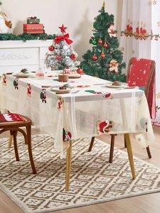 Detail of Christmas tablecloth featuring Santa Claus embroidery and delicate lace edges