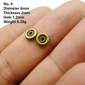 Macro view of a 6mm bronze wheel spacer bead on a finger showing size and detail