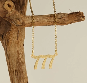 Detailansicht der mattgoldenen Halskette mit der Glückszahl 777 Anhänger am Zweig
