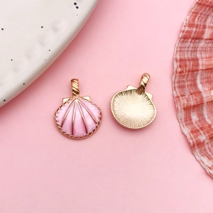 Macro shot of front and back pink shell charms with gold plating for jewelry DIY