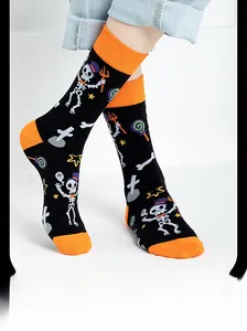 Detail of Halloween crew socks featuring skull patterns and orange patchwork on a model