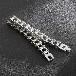 Detailed macro view of 11mm silver stainless steel bike chain bracelet on black surface