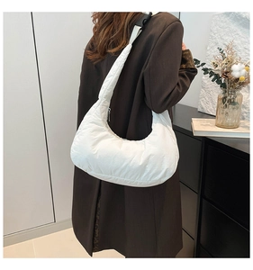 Detail of white padded crescent bag with wide adjustable shoulder strap and buckle
