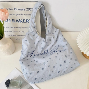 Detail der blauen Stofftasche mit Blumenmuster und dem Sozakka Time Schriftzug