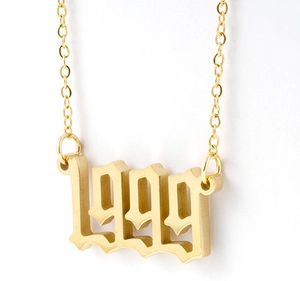 Gros plan du pendentif numéro 1999 gothique en acier inoxydable doré sur fond blanc