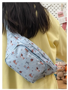 Detail showing a light blue crossbody bag with dachshund prints worn on the back