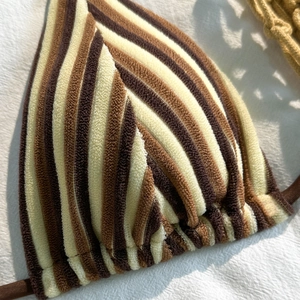 Macro view of soft terry knit striped bikini top with brown and beige retro texture