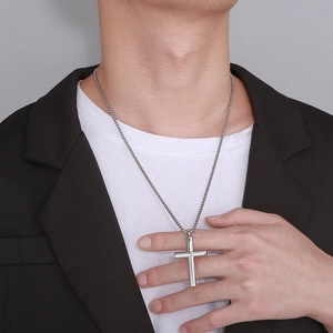 Minimalist silver stainless steel cross pendant necklace for men worn by a male model