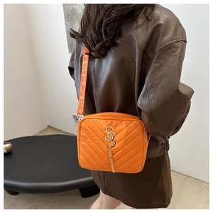Detail of orange quilted nylon crossbody camera bag with wide LOVE strap and gold hardware