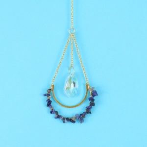 Detail of crescent moon pendant with blue stones and rainbow crystal prism drop