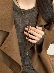 Detail of wooden rocking horse pendant on a brown cord necklace over winter clothing