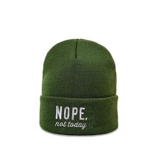Detailansicht der feinen Strickstruktur und NOPE Stickerei auf einer dunkelgrünen Mütze