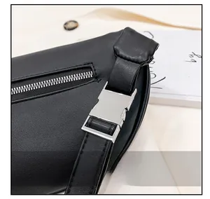 Detail view of premium silver hardware buckle and smooth metal zipper on black leather bag