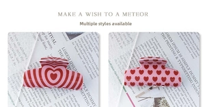 Detail of red heart pattern hair claws with glossy finish on a stylish background