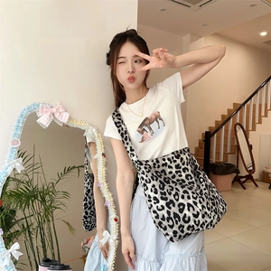 Close-up of a large leopard print canvas crossbody bag featuring a wide comfortable strap
