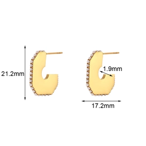 Macro view of C-shaped 18K gold stainless steel earrings with pearl side inlays