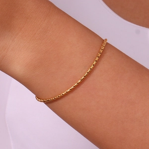 Detail of minimalist 18K gold plated stainless steel box chain bracelet on wrist