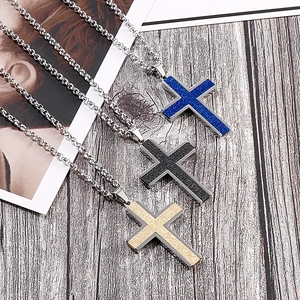 Three creative cross pendant necklaces in blue black and gold on a rustic wood background