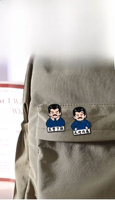 Cartoon metal badges featuring Lu Xun with humorous slogans on a canvas bag detail