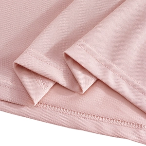 Detail of pink polo shirt showing pique mesh texture and precise double-needle stitching