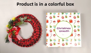 Christmas wreath with plaid ribbon, pine cones, and berries beside a festive gift box