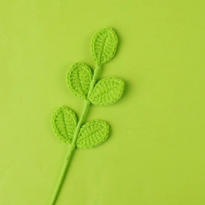 Close-up of green hand-crocheted yarn leaves with detailed knitted texture for floral decor