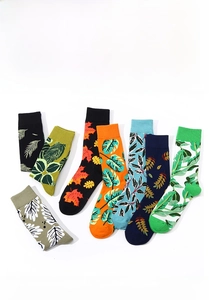 Detail view of colorful cotton crew socks featuring various tropical leaf print patterns