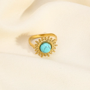 Gros plan détaillé d'une bague tournesol dorée avec une pierre précieuse turquoise bleue