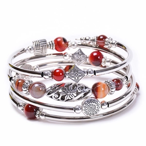 Close-up of silver multilayer wrap bracelet with agate-colored beads and ethnic patterns