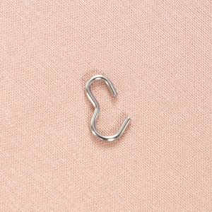 Polished silver stainless steel S-shaped hook fastener for jewelry making on pink fabric