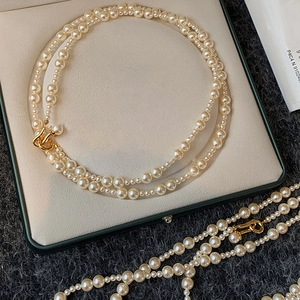 Close-up of elegant double-layered white pearl necklace with golden metal clasp detail