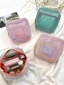 Set of four colorful mesh makeup bags in pink, green, lilac, and orange for cosmetics storage