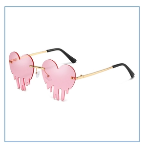 Detail of pink melting heart sunglasses with gold metal frames and dripping lens design