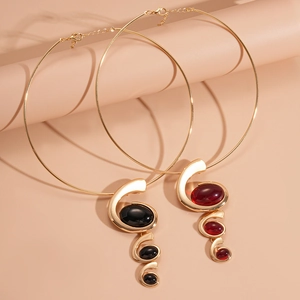 Detail of gold metal collars with black and dark red oval resin stone pendants