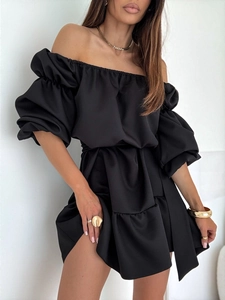 Détail d'une robe noire à épaules dénudées avec manches bouffantes et taille marquée