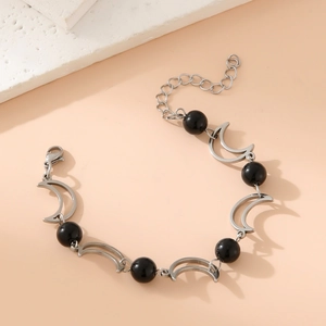 Stainless steel bracelet featuring silver moon pendants and black beads on textured background