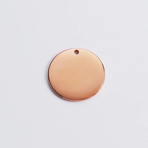 Macro shot of 18k rose gold plated round pendant with smooth surface and hanging hole
