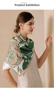 Detail of silk-feel scarf featuring elegant rose floral print in forest green and beige