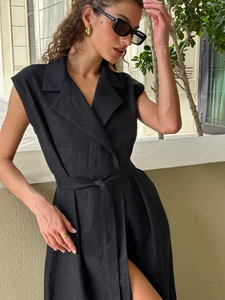 Detail of a sleeveless black shirt dress featuring a lapel collar and waist tie belt