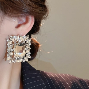 Detailed close-up of crystal leaf earrings on a model showing elegant luxury jewelry design