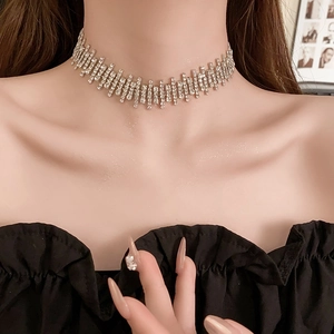 Macro shot of silver tassel choker with sparkling rhinestones on a female model