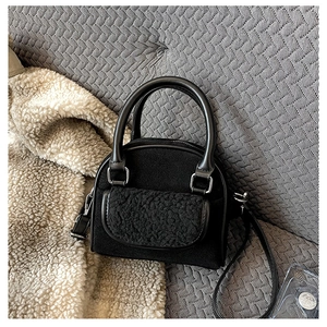 Detail of plush faux fur texture and matte black material on women's handbag