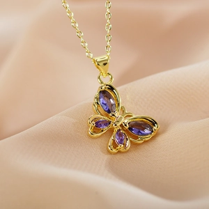 Elegant gold butterfly pendant necklace with purple gemstones on soft silk background