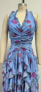 Detail eines blauen Blumenkleides aus Chiffon mit Neckholder-V-Ausschnitt und Taillenrüschen