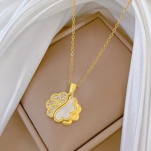 Detail of gold flower pendant with sparkling crystals and white mother of pearl inlay